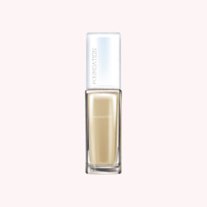 Liquid foundation in a transparent glass bottle with a silver cap.
