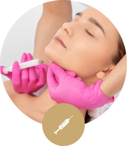 Woman receiving a cosmetic injection on her chin from a professional wearing pink gloves.