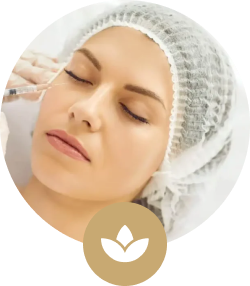 Woman receiving a cosmetic injection on her face while wearing a hair cap, with a wellness icon overlay.