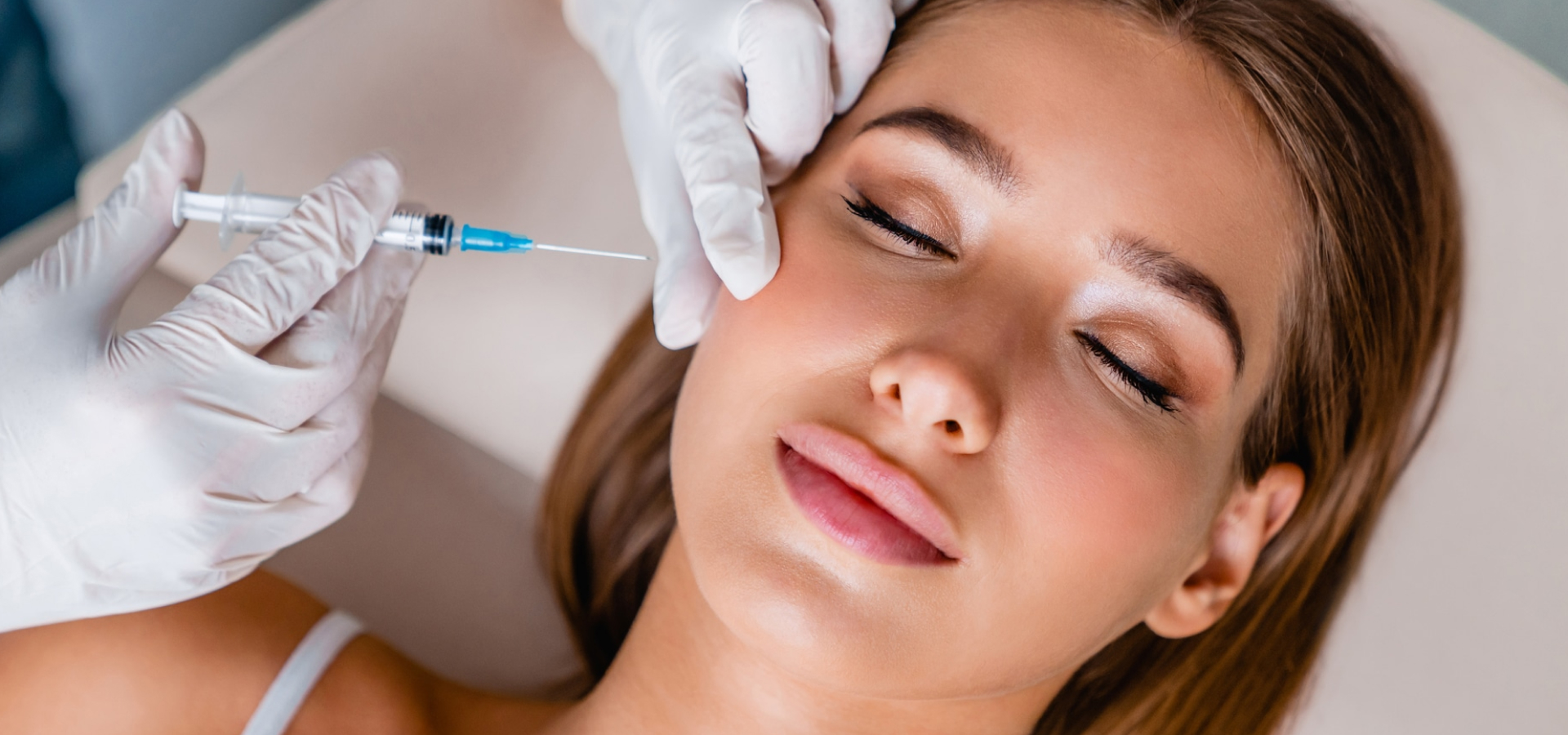Woman receiving a cosmetic injection on her face.